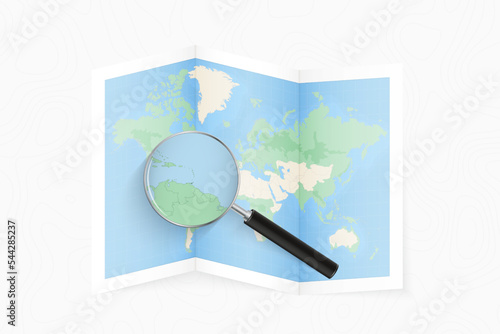 Enlarge Trinidad and Tobago with a magnifying glass on a folded map of the world.