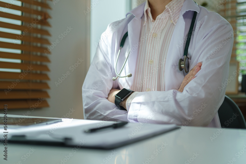 Cropped shot of doctor sitting with arms crossed gesture at medical office. Cropped shot of doctor sitting with arms crossed gesture at medical office.