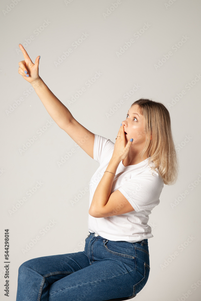 the girl shows her finger and is surprised the girl shows her finger and is surprised