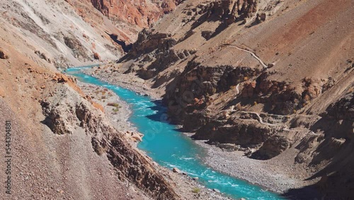 4K shot of the blue Tsarap River flowing besides the Phugtal monastery in Zanskar Valley in Ladakh, India. Clear blue water of the river on the way towards the Phuktar gompa. Blue river in Zanskar photo