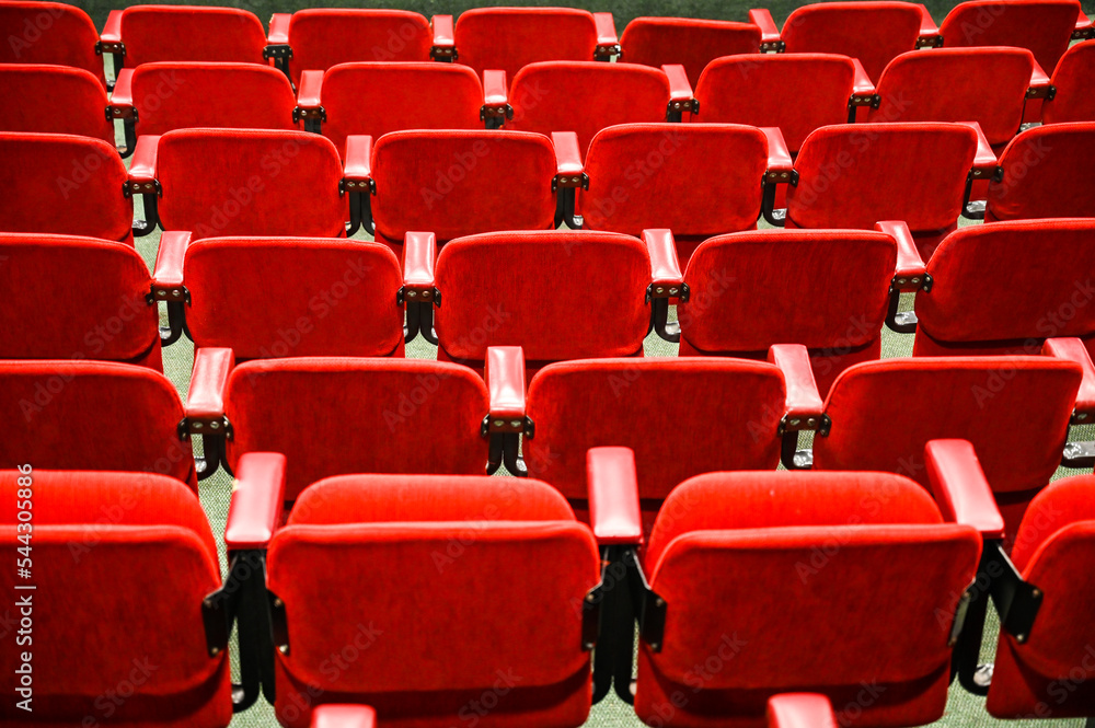 Naklejka premium Red chairs in cinema. Rows of chairs in theatre.