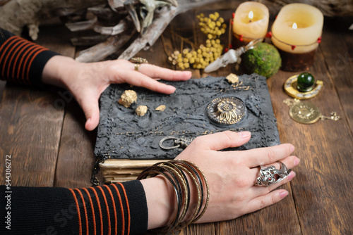 Photography Magician is reading magic book by her table close up