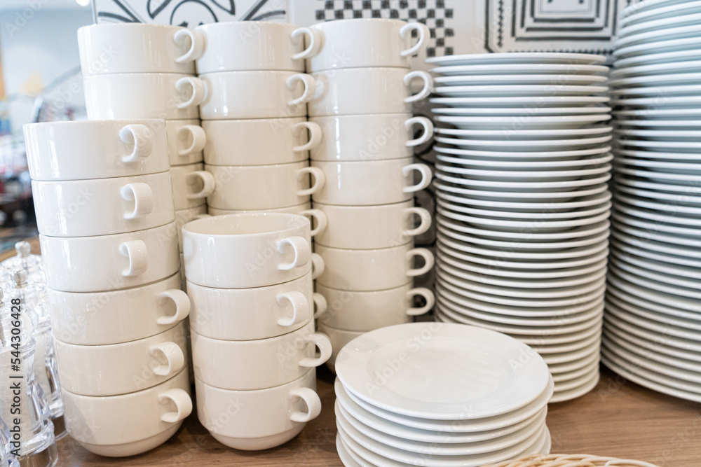 Stacks of Clean Mugs, Bowls, Plates at Hotel Breakfast Buffet Stacks of Clean Mugs, Bowls, Plates at Hotel Breakfast Buffet