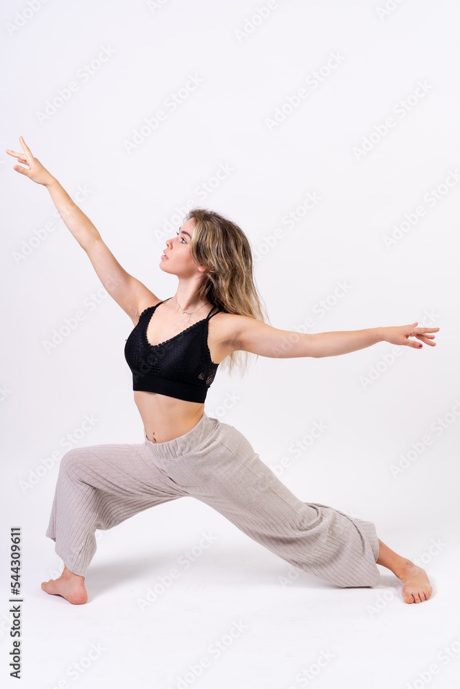 Young dancer in studio photo session with a white background, ballet, performing stretching Young dancer in studio photo session with a white background, ballet, performing stretching