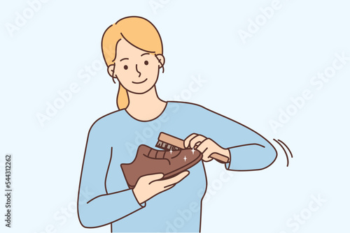 Smiling woman polish shoes with brush