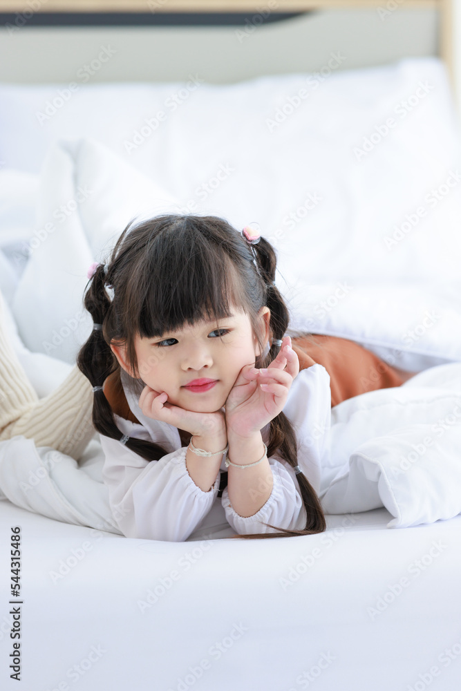 Millennial Asian young beautiful mother in sweater waking up laying down smiling together under thick warm blanket on bed in morning with little cute preschooler daughter girl in bedroom at home Millennial Asian young beautiful mother in sweater waking up laying down smiling together under thick warm blanket on bed in morning with little cute preschooler daughter girl in bedroom at home