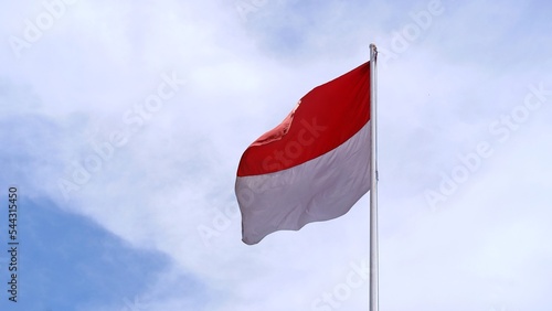Indonesian national flag fluttering against the cloudy sky background