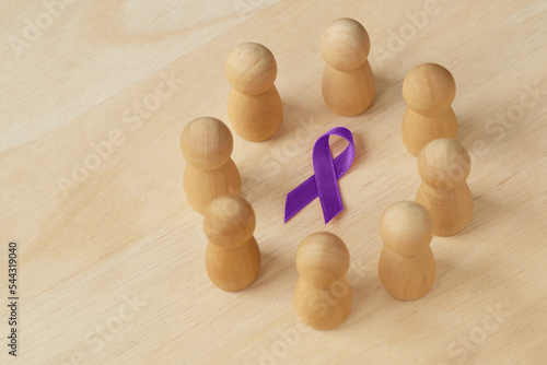 Wooden pawn in a circle around violet ribbon - Concept of Domestic Violence awareness; Alzheimer's disease, Pancreatic cancer, Epilepsy awareness and Hodgkin's Lymphoma photo