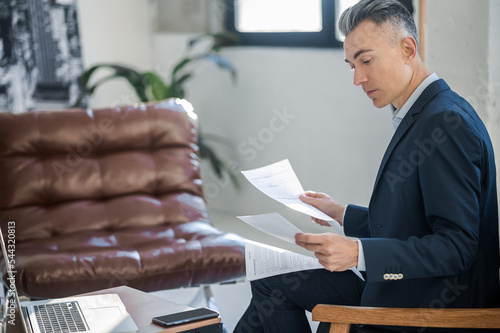 Mid aged elegant businessman working in the offie photo