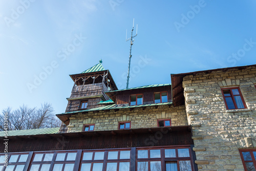 Mountain shelter on Szyndzielnia Mountain, Bielsko-Biala, Silesia, Poland seen from below. Building made of stone and wood and build by the end of XIX century. Wooden tower. Sunny, autumn day. photo