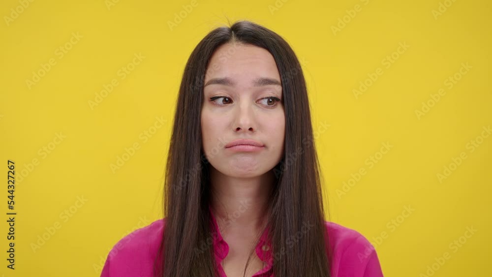 Confused woman shrugs and purses lips looking thoughtful Confused woman shrugs and purses lips looking thoughtful