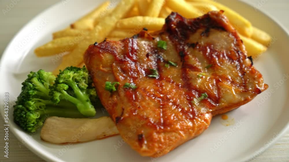 grilled chicken steak with potato chips or french fries on white plate grilled chicken steak with potato chips or french fries on white plate