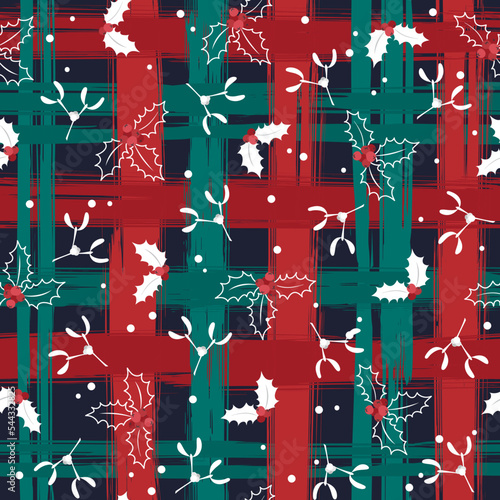 Holly leaves and berries on the background of a checkered pattern in red and green cells. Abstract Christmas pattern made of brush strokes. Seamless pattern. Suitable for wrapping paper and textiles.