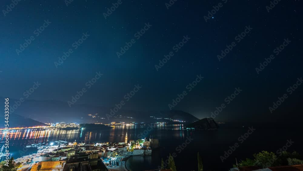 Amazing hyper lapse video of a clear night sky over illuminated Budva Old town and marina with boats, Montenegro. Amazing hyper lapse video of a clear night sky over illuminated Budva Old town and marina with boats, Montenegro.