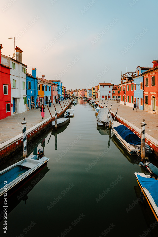 Picturesque canal street with tourists and colorful houses in Burano
