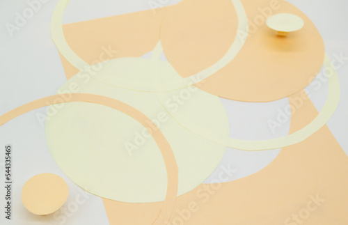 Abstract background with 3D paper elements in beige, orange colors resembles female forms - chest, abdomen. Backdrop advertising products, copy space