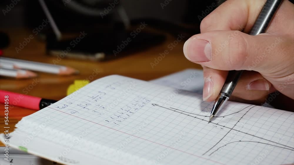 Student learn math for a test, exam. Making chart of functions in a notebook. Distance learning at home. Student learn math for a test, exam. Making chart of functions in a notebook. Distance learning at home.