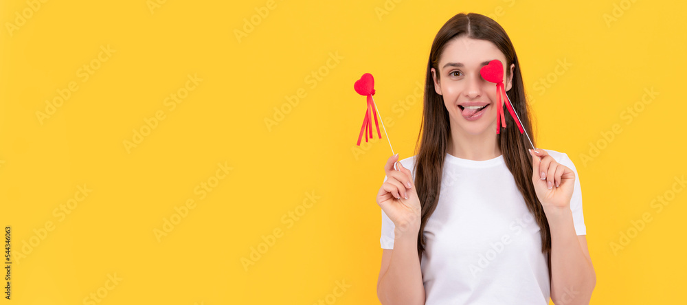 Woman isolated face portrait, banner with copy space. positive girl hold heart in white shirt on yellow background, 14 february. Woman isolated face portrait, banner with copy space. positive girl hold heart in white shirt on yellow background, 14 february.