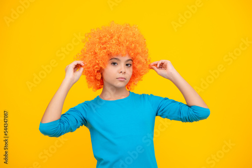 Beautiful teenage girl in wig isolated on yellow. Funny clown wig.