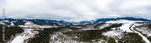 Carpathian slopes in the snow, view of the mountains from above, drone panorama.
