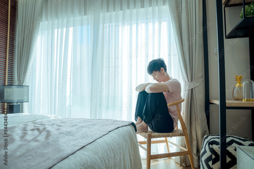 Asian gay men floating around thinking about their boyfriend by the window in the bedroom.LGBT gay couple relationship lifestyle concept Asian gay men floating around thinking about their boyfriend by the window in the bedroom.LGBT gay couple relationship lifestyle concept