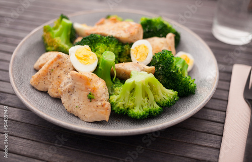 pieces of fried chicken breast with boiled broccoli and quail eggs on plate for lunch