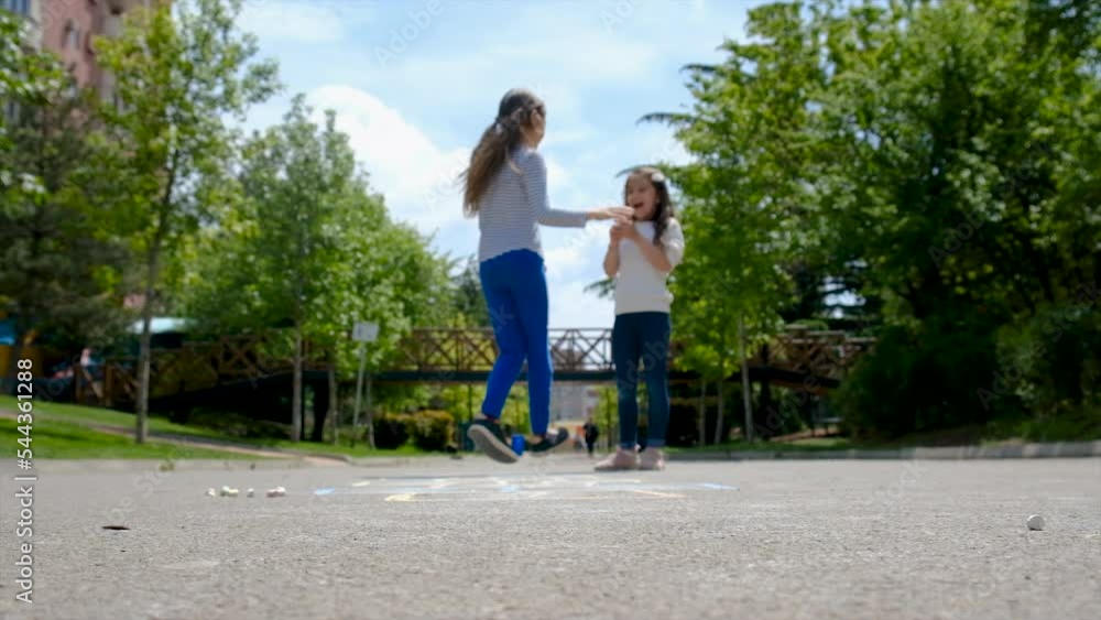 Children jump hopscotch on asphalt. Selective focus. Children jump hopscotch on asphalt. Selective focus.