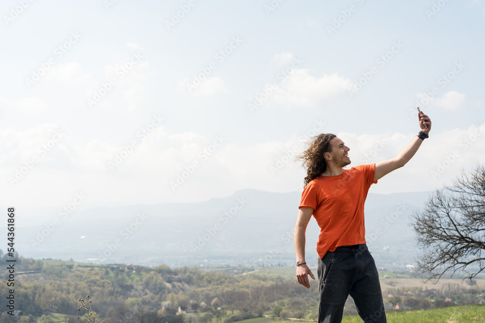 Young man making selfie on mobile phone on the hill Young man making selfie on mobile phone on the hill