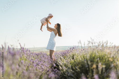 Fototapeta Naklejka Na Ścianę i Meble -  happy mom holds her daughter in her arms, smiles and rejoices