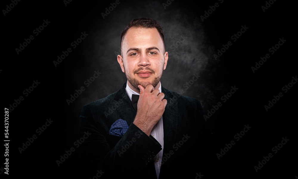 Handsome young fashionable man on a dark background.