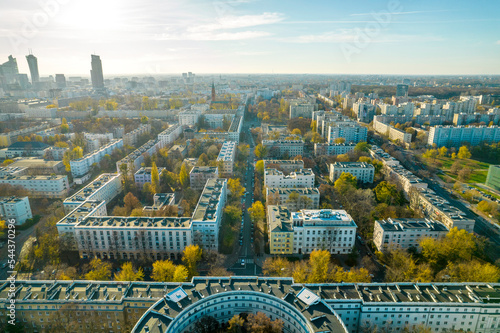 Piękny panoramiczny widok z drona na centrum nowoczesnej Warszawy z sylwetkami drapaczy chmur. Na pierwszym planie Muranów – zielona dzielnica Warszawy. Jesienny krajobraz miasta.
