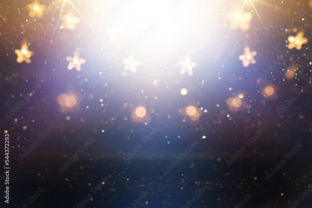 Fototapeta premium Christmas warm gold garland lights over dark background with glitter overlay