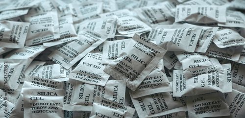 Photos A bunch of desiccant or silica gel in white paper packaging.