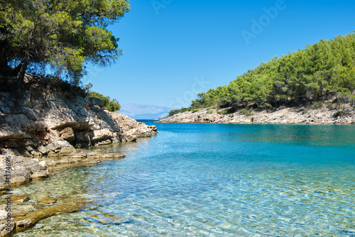Hvar island coastline in Summer. Maslinica Beach, Public bathing wild pebble beach near Vrboska village. Wild pine forest on coast of Adriatic Sea. Hvar island, Dalmatia, Croatia. photo