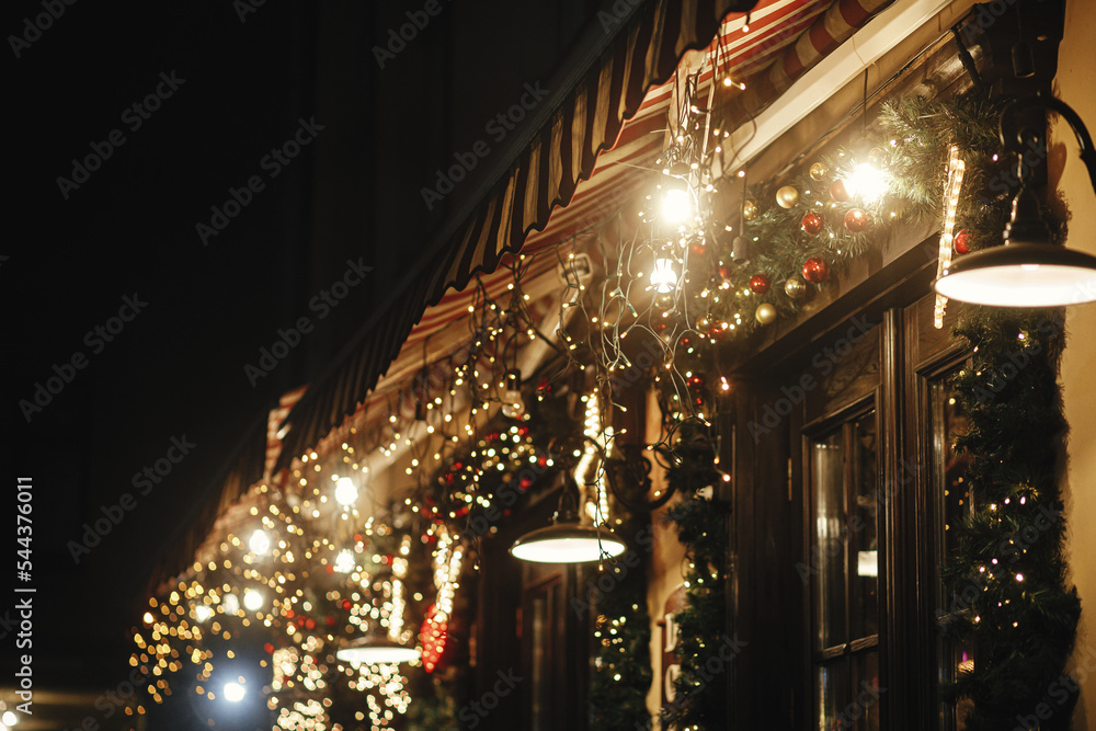 Stylish christmas illumination and festive lights on fir branches in evening outdoor. Modern christmas decor in city street. Atmospheric winter holidays in Europe. Merry Christmas! Stylish christmas illumination and festive lights on fir branches in evening outdoor. Modern christmas decor in city street. Atmospheric winter holidays in Europe. Merry Christmas!