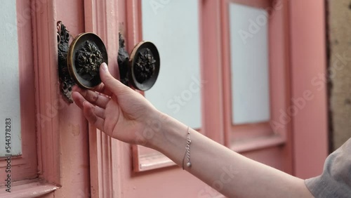 close-up woman touching antique door handle