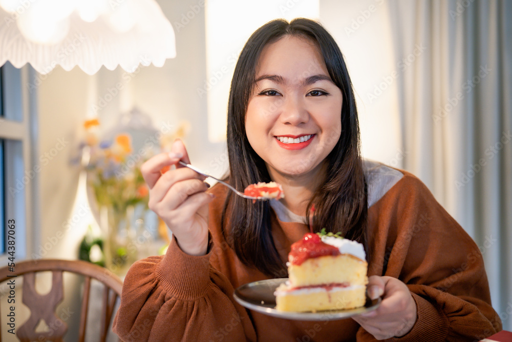 Beautiful Asian woman eating tasty cake. Teen girl eating the cake. Beautiful Asian woman eating tasty cake. Teen girl eating the cake.