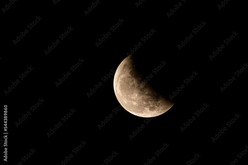 Obraz premium The partial lunar eclipse is caused by the earth moving between the sun and moon, but not perfectly in alignment. Blood Moon Eclipse Crescent moon with its craters