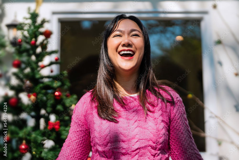 Happy smile asian woman standing behind Christmas tree, Holiday celebration concept.