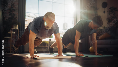Middle Aged Man Exercising at Home with Personal Trainer. Senior Male Strengthening Body Muscles with Push-Ups Workout. Son Training with Sporty Father, Motivating Each Other to Be in Better Shape.