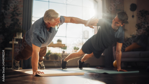 Middle Aged Man Exercising at Home with Personal Trainer. Senior Male Strengthening Body Muscles with Push-Ups Workout. Son Training with Sporty Father, Motivating Each Other by Giving a High Five.