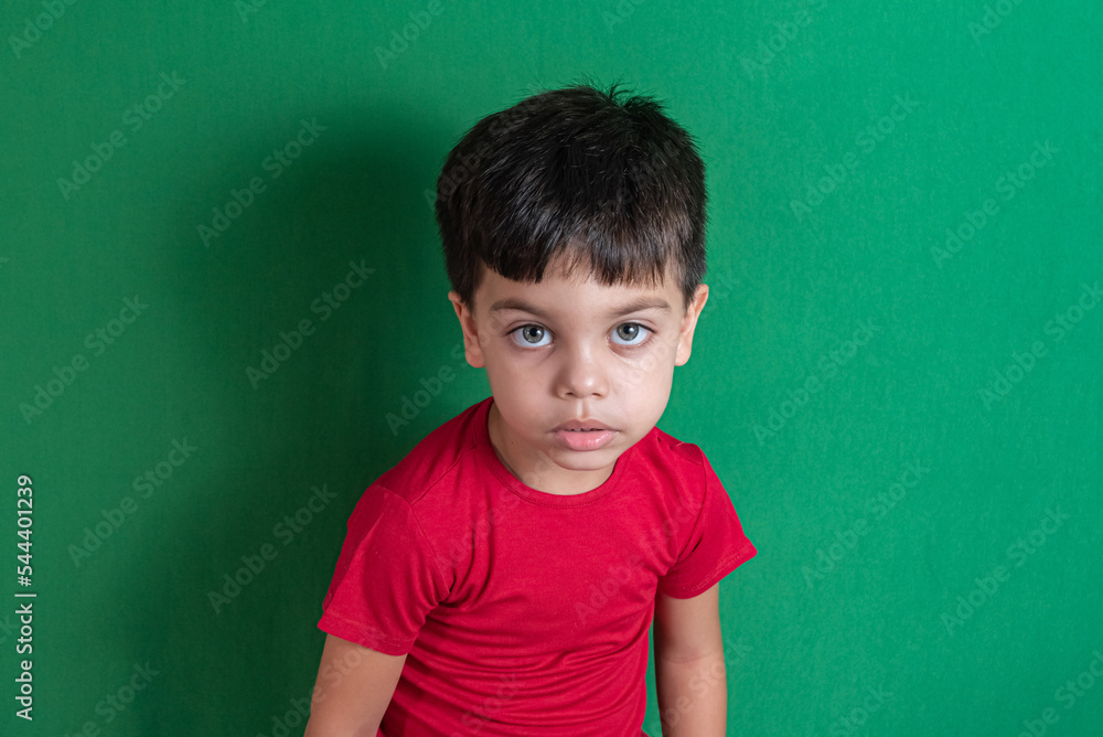 Kid in red t-shirt on the green background Kid in red t-shirt on the green background