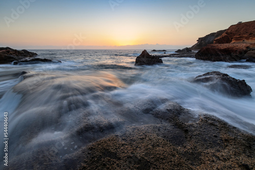 Rocky shore of the Atlantic Ocean at high tide at sunset
