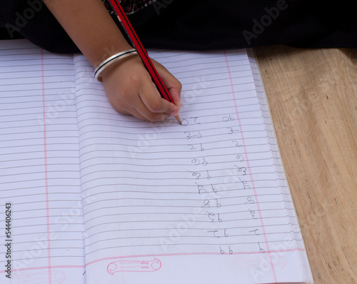 Girl Kid or toddler writing number in hindi or devnagri lipi or script notebook. Girl education, Learn Hindi and home schooling concept. Happy Mathematics Day and Hindi Diwas concept photo