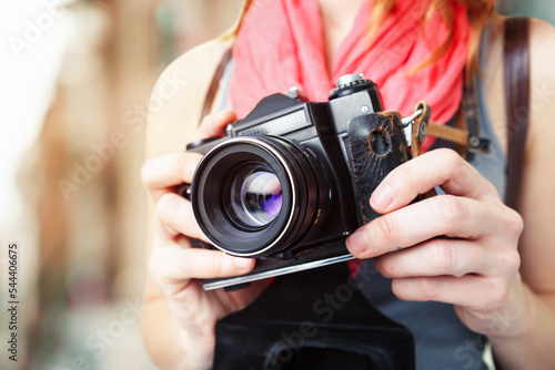 Woman photographer holding old 35mm film camera. photo