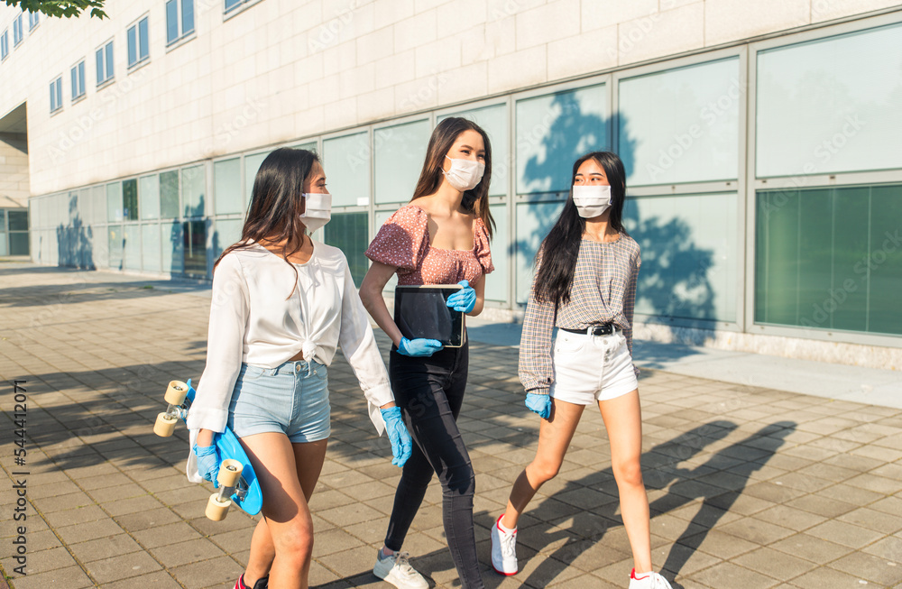 Obraz premium Young female Friends meeting outdoors coronavirus during pandemic flu - Asian girls wearing face masks for covid-19 quarantine