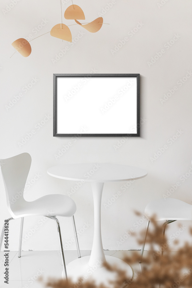 Fototapeta premium Clean minimal frame mockup on the white wall with table and chairs
