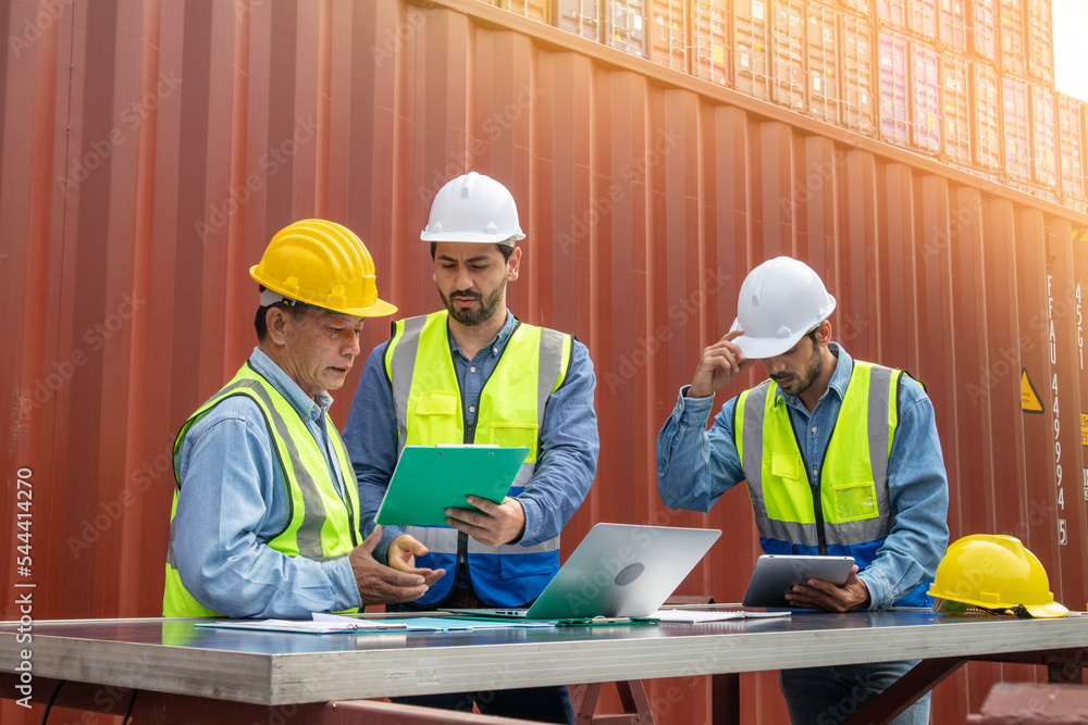 The foreman team has a meeting in the cargo container area. Container import export and logistic concept The foreman team has a meeting in the cargo container area. Container import export and logistic concept