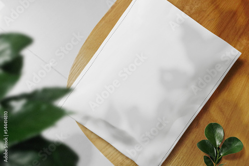 Clean minimal packaging mockup on top chair with leaves