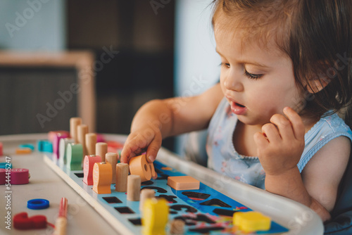 Canvastavla Baby girl playing with different color wooden elements making tasks for education and brain exercise